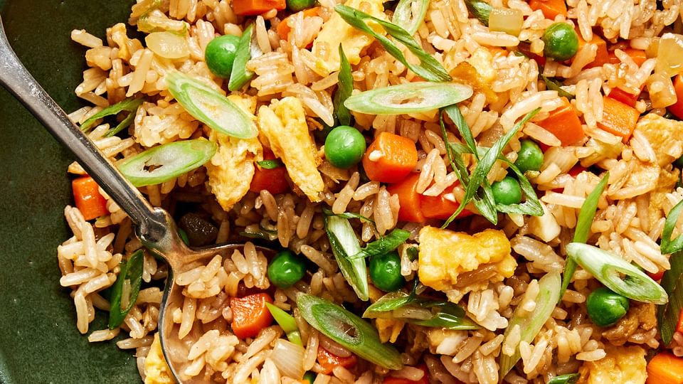 A bowl of homemade fried rice with  scrambled egg, vegetables, and green onions tossed with coconut aminos and soy sauce