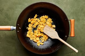 egss whisked with coconut aminos and sesame oil being scrambled in a skillet