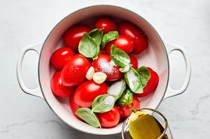 tomatoes, olive oil, salt, garlic and fresh basil in a pot to make homemade tomato sauce