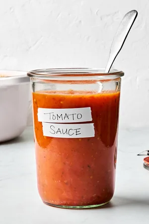 a jar of homemade tomato sauce made with tomatoes, olive oil, salt, garlic and fresh basil