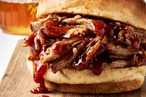 homemade honey chipotle pulled pork being served on a hamburger bun