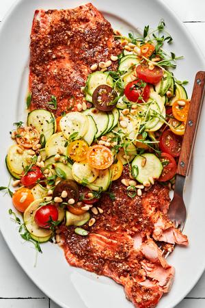 Honey Mustard Salmon with Summer Vegetable Salad garnished with pea tendrils and pine nuts on a serving platter