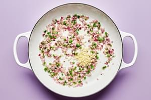 chopped red onion, jalapeño and garlic being cooked in butter in a skillet
