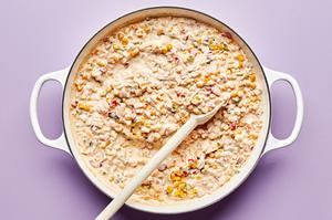 hot corn dip in a skillet made with cream cheese, sour cream, mayo, jalapeño, red onion, cheese & spices