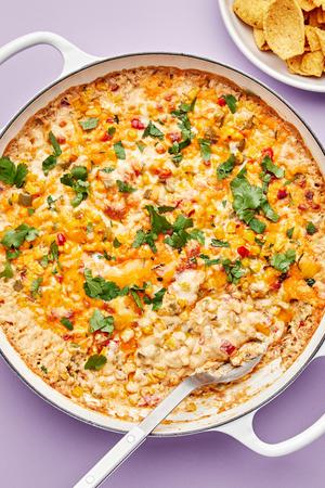 hot corn dip in a skillet made with cream cheese, butter, sour cream, mayo, cheese, jalapeño and spices