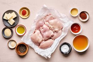 spices, chicken thighs, olive oil, butter, honey, sriracha and apple cider vinegar in prep bowls to make hot honey chicken