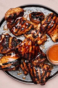 a plate of hot honey grilled chicken served with a dish of extra hot honey sauce on the side