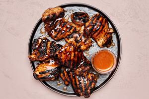 a plate of hot honey grilled chicken served with a dish of extra hot honey sauce on the side