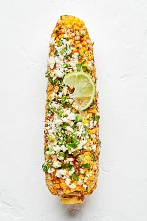 a grilled corn on the cob seasoned with butter, salt, chili powder, jalapeño, cilantro and Cotija Cheese