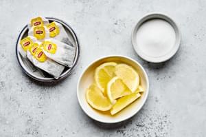 black tea bags, lemon wedges and sugar in prep bowls to make iced tea