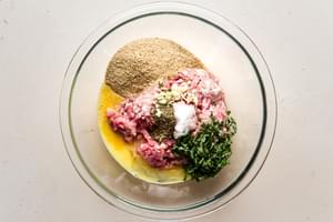 bread crumbs, eggs, basil, port, salt and italian seasoning in a bowl for meatballs