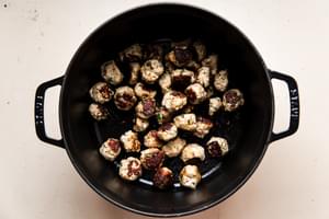 Italian pork meatballs browned in a soup pot