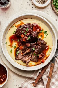 Italian Pot Roast served over creamy polenta sprinkled with fresh parsley