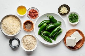 jalapeños, parmesan, cream cheese, bacon, chives, butter, panko & spices in prep bowls to make jalapeno poppers