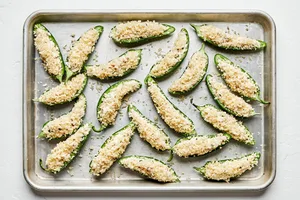 halved jalapenos filled with and creamy, cheesy filling topped with breadcrumbs ready to be baked