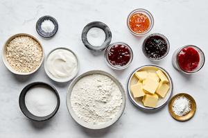 flour, baking soda, baking powder, salt, sugar, butter, yogurt, oats and jam in prep bowls to make jam dot oat scones