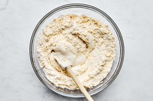 yogurt and oats being stirred in a bowl with butter, flour, baking soda, baking powder, salt and sugar in