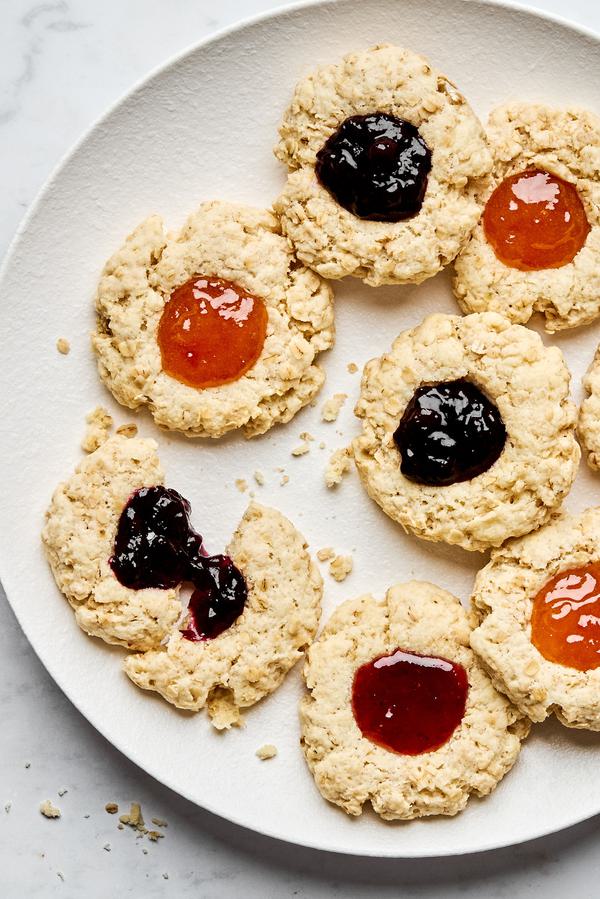 a plate of homemade jam dot oat scones filled with assorted fruit jams
