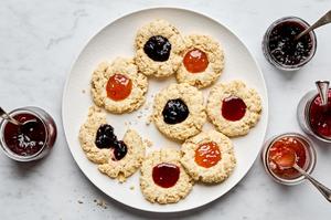 a plate of homemade jam dot oat scones filled with assorted fruit jams