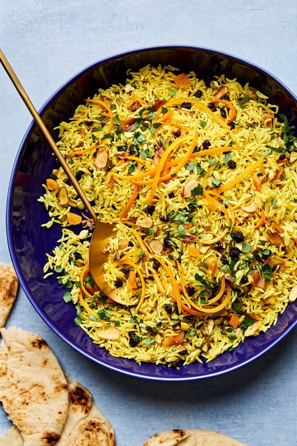a bowl of jeweled rice made with pistachios, almonds, shallot, turmeric, cumin, cinnamon, all spice, salt and dried fruit