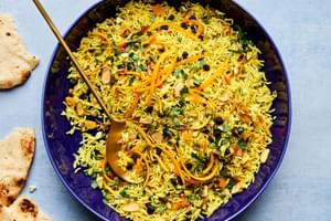 a bowl of jeweled rice made with pistachios, almonds, shallot, turmeric, cumin, cinnamon, all spice, salt and dried fruit