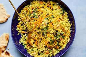 a bowl of jeweled rice made with pistachios, almonds, shallot, turmeric, cumin, cinnamon, all spice, salt and dried fruit