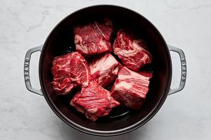 salted chunks of chuck roast being cooked in a pot