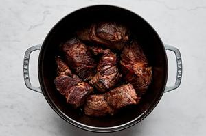 salted chunks of chuck roast being cooked in a pot