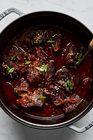 chuck roast being cooked in a pot with onions, garlic, ginger, beef stock, gochujang paste, brown sugar & soy sauce