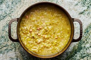 Leeks, onions, chickpeas, thyme cooked in chicken stock in a large cast iron pot.