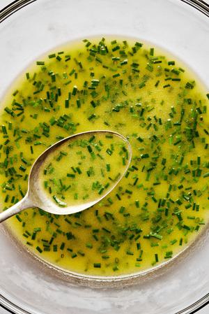 homemade lemon vinaigrette in a bowl with a spoon made with lemon juice, dijon mustard, sugar, salt, olive oil and chives