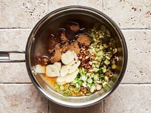 lemongrass, green onions, garlic, fish sauce, brown sugar, lime juice, red pepper flakes, and water cooking in a small pot