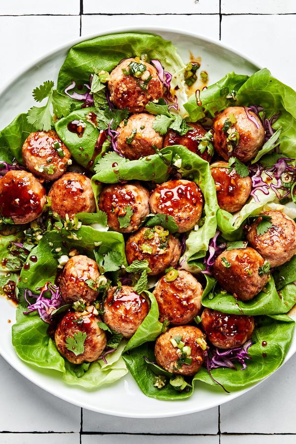 Lemongrass Meatball Lettuce Cups sprinkled with fresh herbs, drizzle with brown sugar sauce and green onion oil.