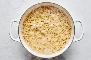 macaroni noodles cooking in a large pot of salted water