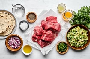 ingredients laid out for Margarita Beef: raw beef, lime and orange juices, olive oil, tequila, salt and pepper
