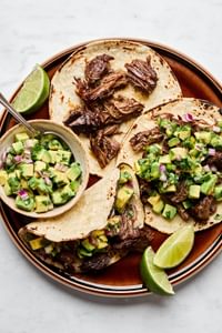 Margarita Beef tacos served in warm corn tortillas, topped with vibrant avocado salsa.