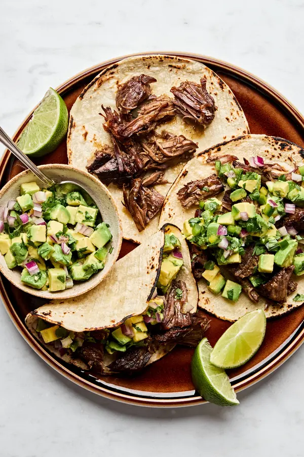 Margarita Beef tacos served in warm corn tortillas, topped with vibrant avocado salsa.
