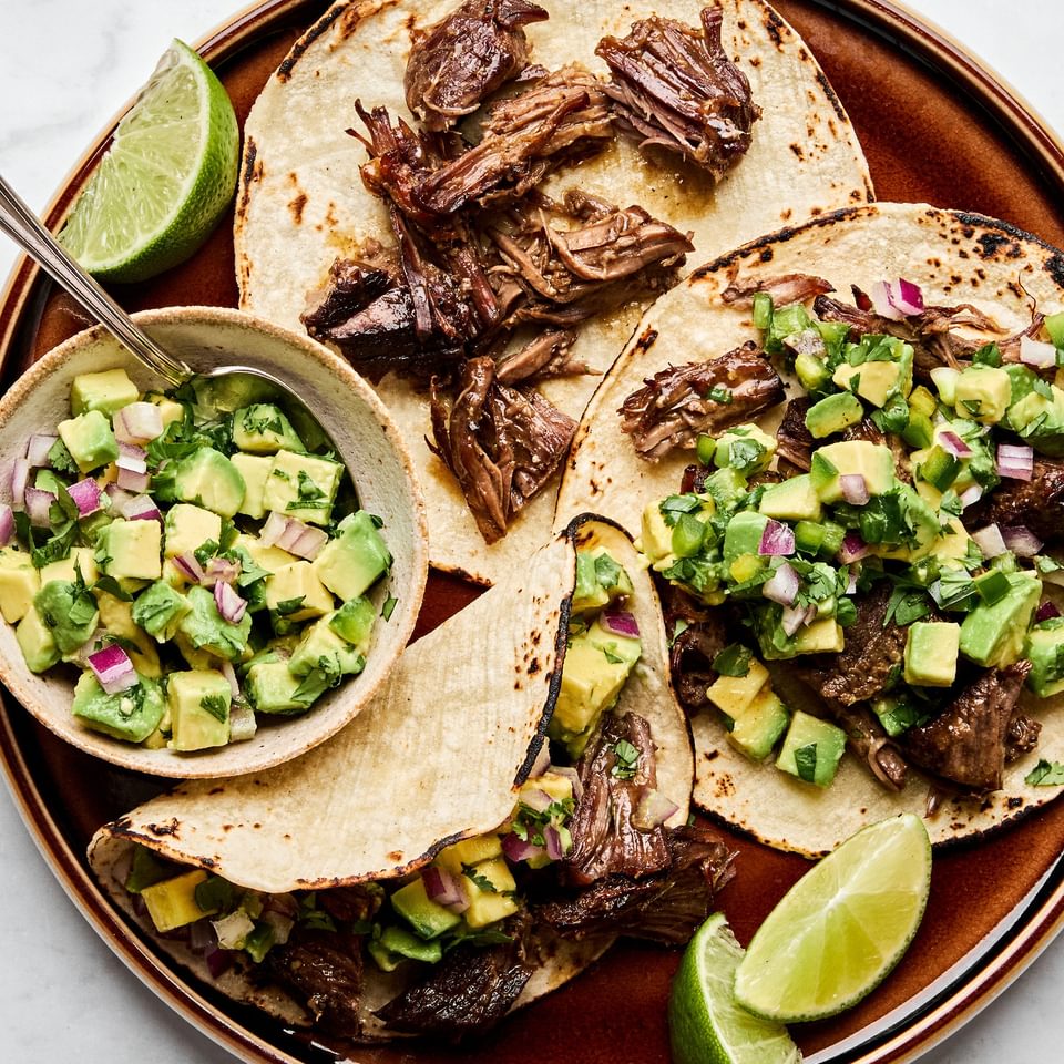 Margarita Beef tacos served in warm corn tortillas, topped with vibrant avocado salsa.