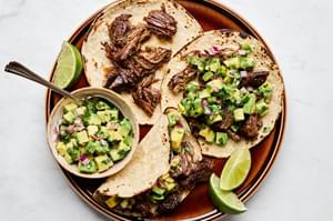 Margarita Beef tacos served in warm corn tortillas, topped with vibrant avocado salsa.