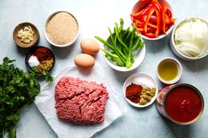 ground beef, eggs, bell peppers, olive oil, Onion, Cumin, Smoked paprika, Canned whole tomatoes, Garlic, Breadcrumbs