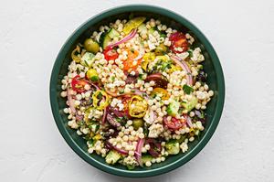 mediterranean couscous salad made with feta, Greek olives, cucumber, tomato, pepperoncini, red onion and parsley