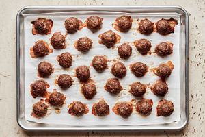 Mediterranean meatballs made with ground beef, onion, spices, parsley, eggs & bread crumbs on a parchment lined baking sheet