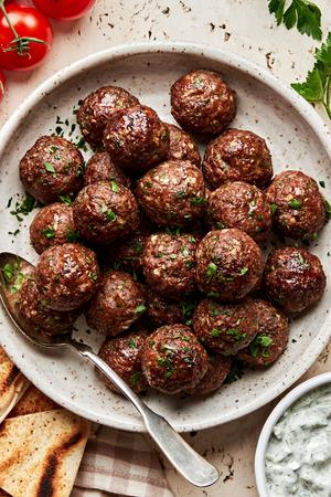 a bowl of mediterranean meatballs made with ground beef, onion, spices, parsley, eggs and bread crumbs