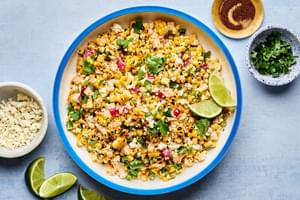 a bowl of Mexican Street Corn Salad with Chipotle Crema made with radishes, green onions, cilantro, cotija and lime juice