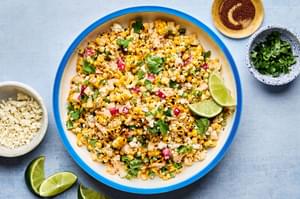 a bowl of Mexican Street Corn Salad with Chipotle Crema made with radishes, green onions, cilantro, cotija and lime juice