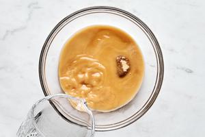 cornstarch, water, brown sugar and soy sauce being mixed together in a bowl