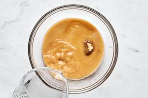 cornstarch, water, brown sugar and soy sauce being mixed together in a bowl