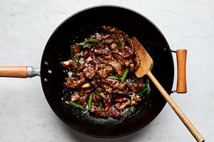 a pan of mongolian beef made with shaoxing wine, soy sauce, brown sugar, ginger, garlic, green onion and chili peppers