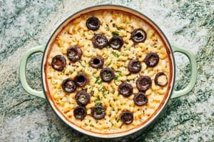 baked mushroom mac and cheese sprinkled with chives in a braiser
