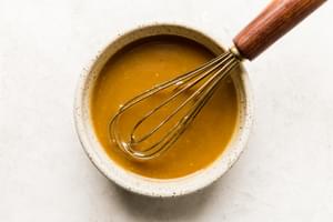 whole grain mustard, Dijon, honey, salt, apple cider vinegar, paprika, and garlic powder in a bowl with a whisk